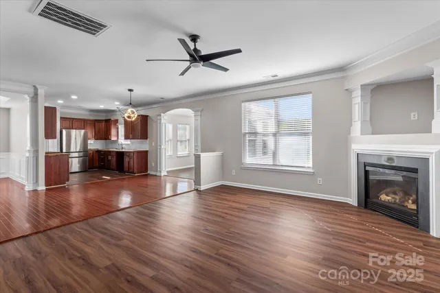 a view of a room with wooden floor and a kitchen