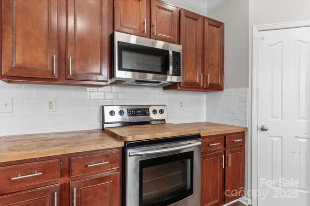 a kitchen with stainless steel appliances granite countertop a stove microwave and sink