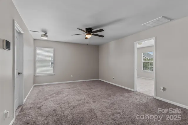 a view of an empty room with a ceiling fan