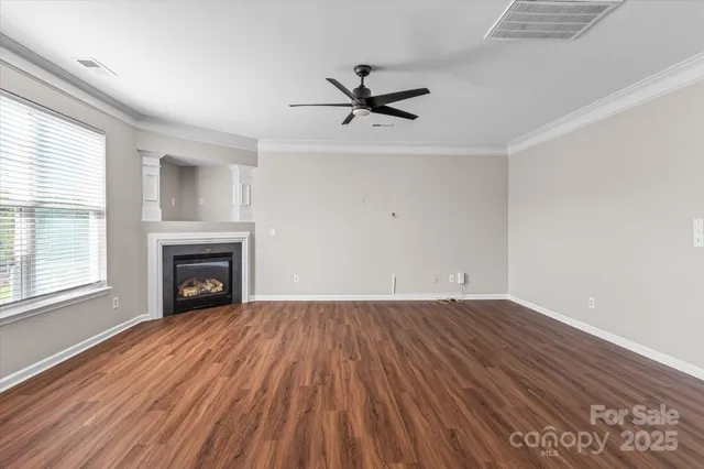 a view of empty room with wooden floor and fireplace