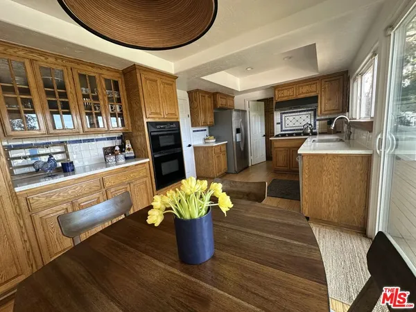 a kitchen with stainless steel appliances granite countertop a stove a refrigerator a kitchen island a table and chairs