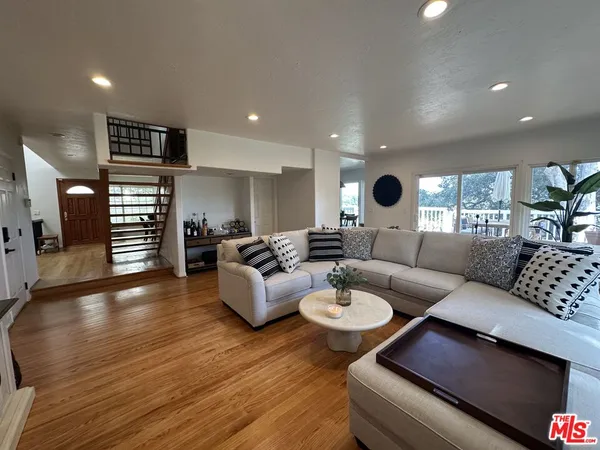 a living room with fireplace furniture and a large window