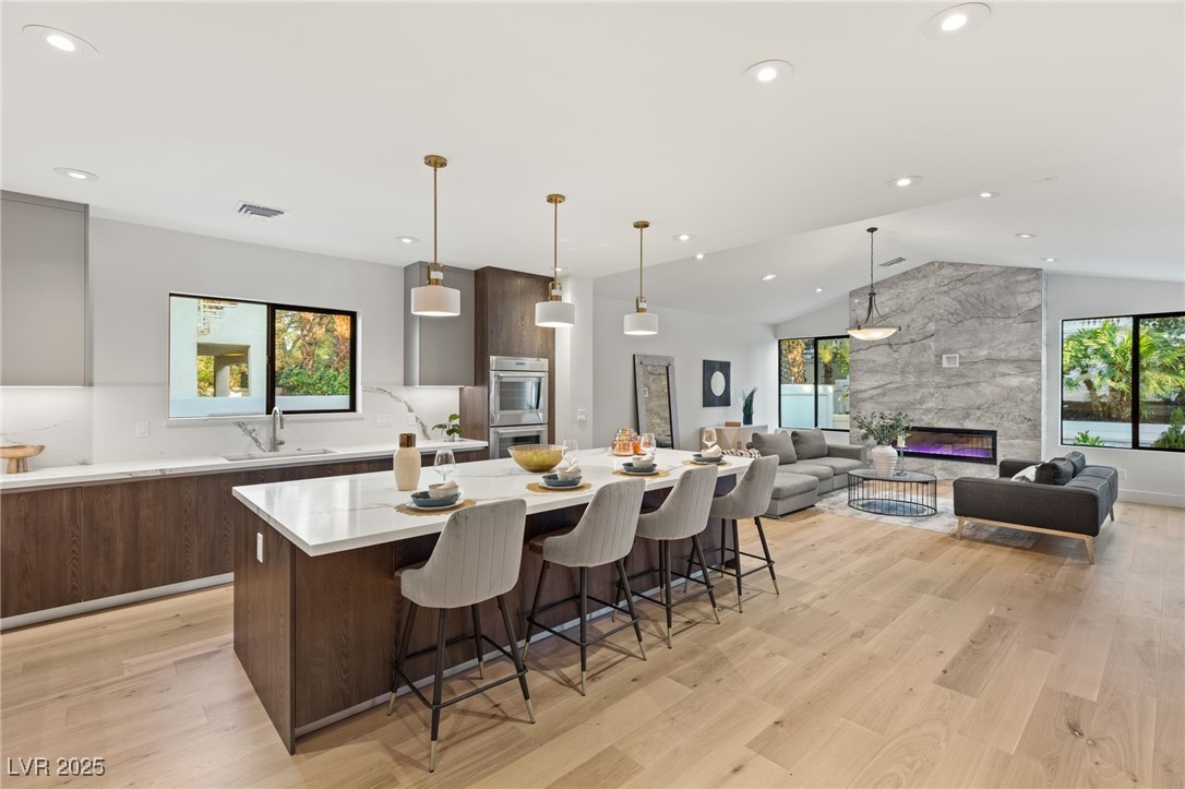 2316 Prometheus Court Henderson, NV 89074 - Photo 17 of 92 Kitchen with modern cabinets, a sink, double oven, a spacious island, and lofted ceiling