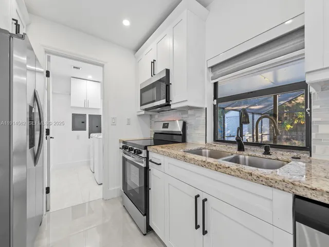 a large white kitchen with a large window