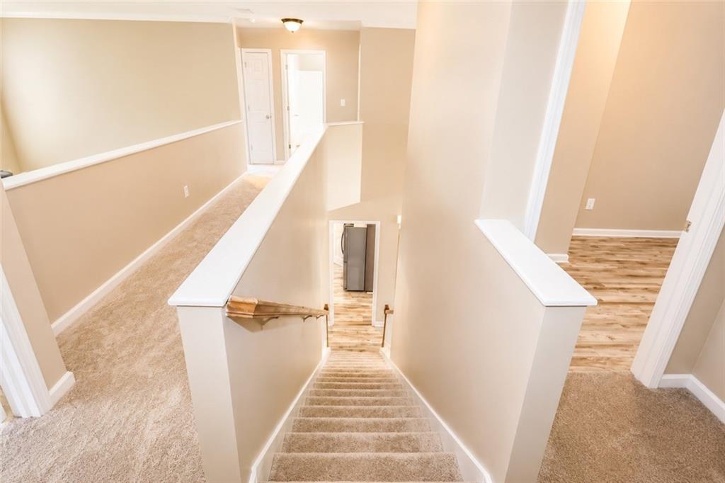 2078 Autumn Ridge Way Auburn, AL 36879 - Photo 19 of 24 Carpeted staircase with white balustrade, wood-finish flooring, and light neutral wall paint