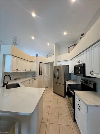 a kitchen with a sink a refrigerator and cabinets