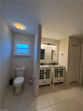 a view of a bathroom with 2 sink and a window