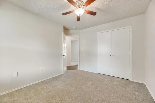 a view of an empty room and chandelier fan