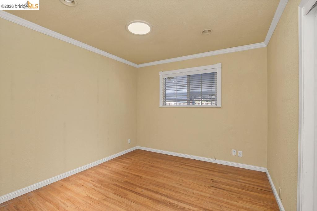 805 Calero Street Milpitas, CA 95035 - Photo 11 of 23 Room featuring wood-finish flooring, a window with blinds, recessed lighting, crown molding, and baseboards