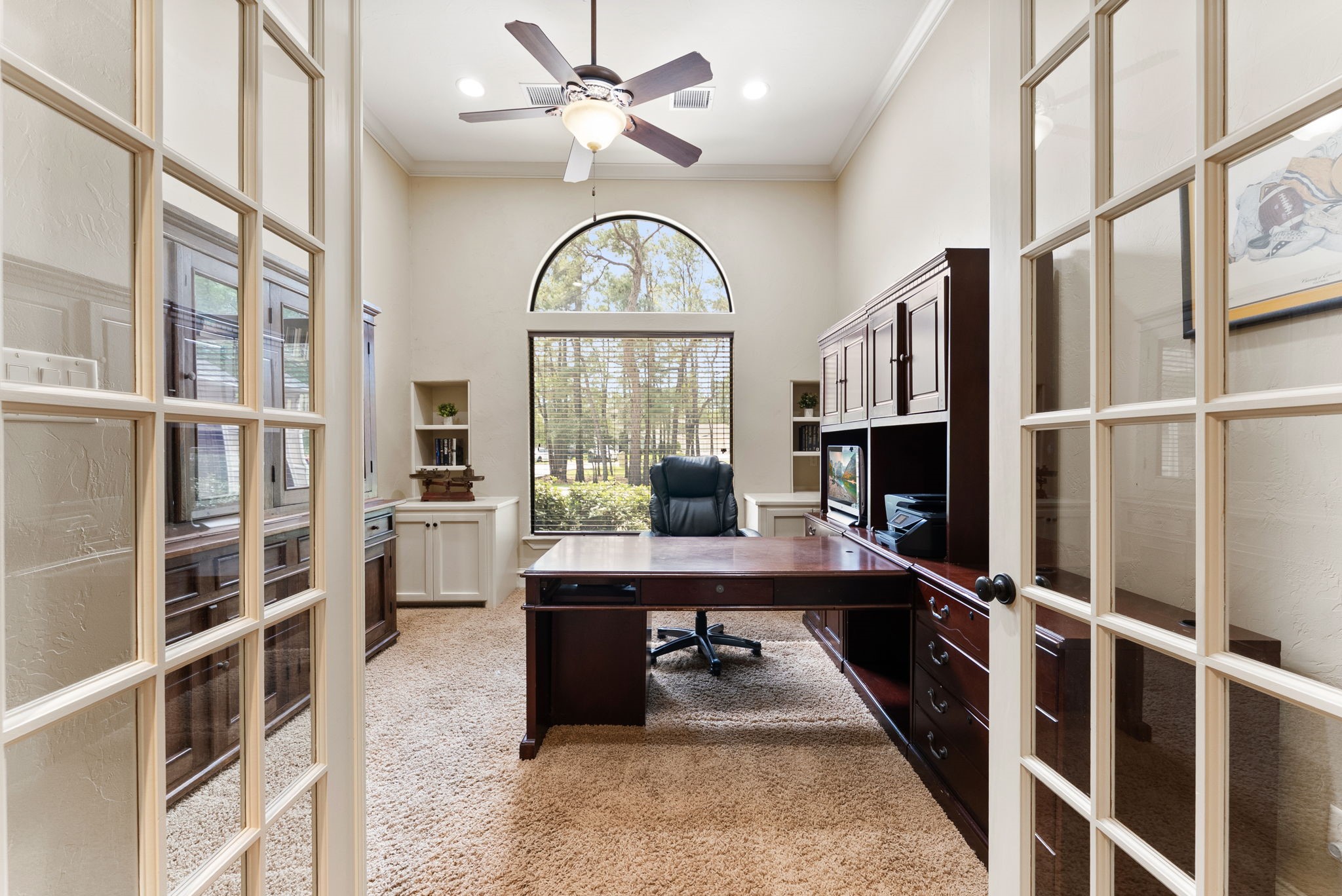 3907 Rayford Road Spring, TX 77386 - Photo 12 of 38 Tucked behind glass French doors, the Study offers a quiet, light-filled space with a large window and upper transom, high ceilings, crown molding, and built-ins—ideal for working from home.