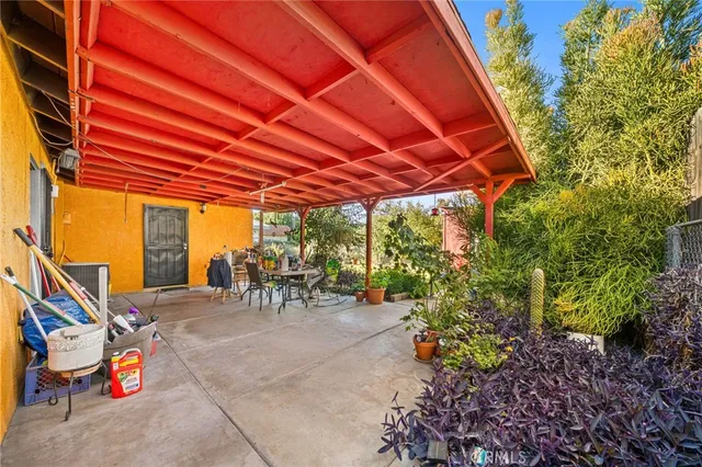 a view of a patio with table and chairs under an umbrella