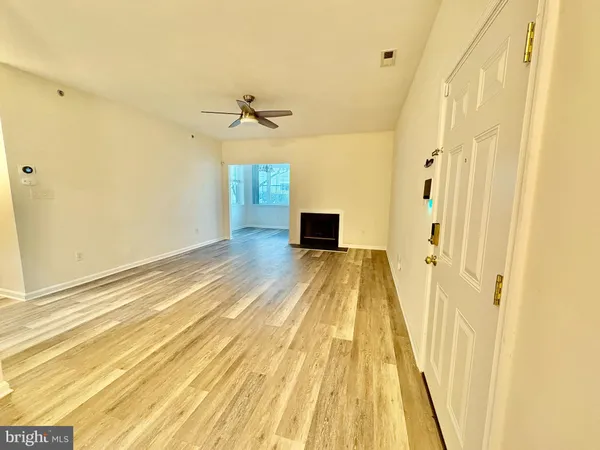 a view of a room with wooden floor and door
