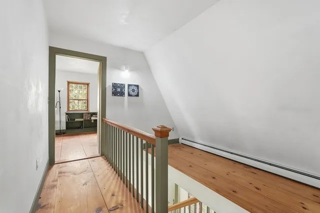 a view of a hallway view with wooden floor and staircase