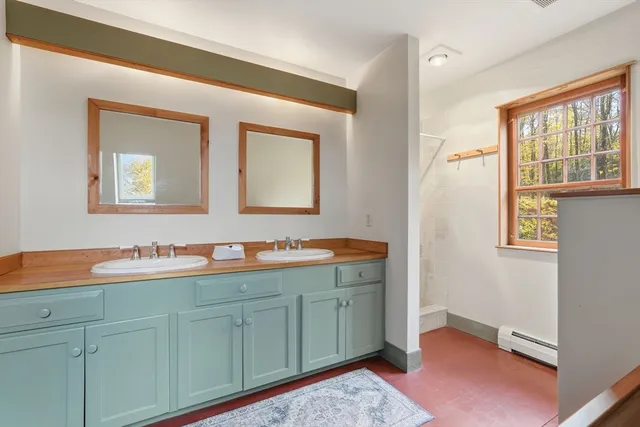 a spacious bathroom with 2 sink and a mirror