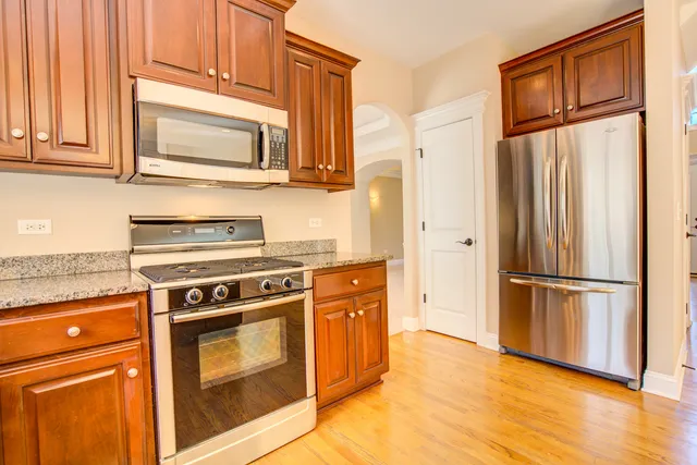 a kitchen with stainless steel appliances granite countertop a refrigerator stove and a sink