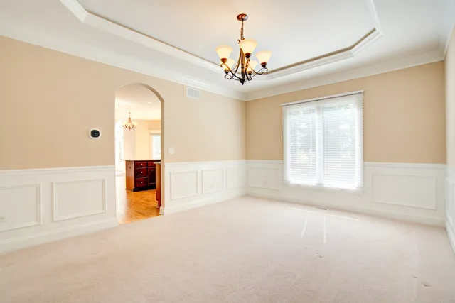 en empty room with windows and chandelier