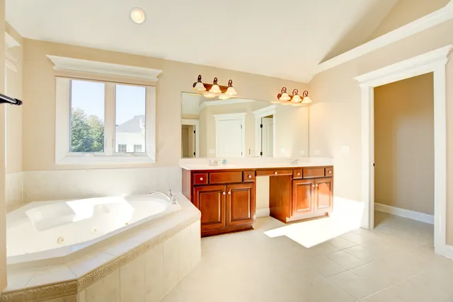 a spacious bathroom with a tub sink and mirror