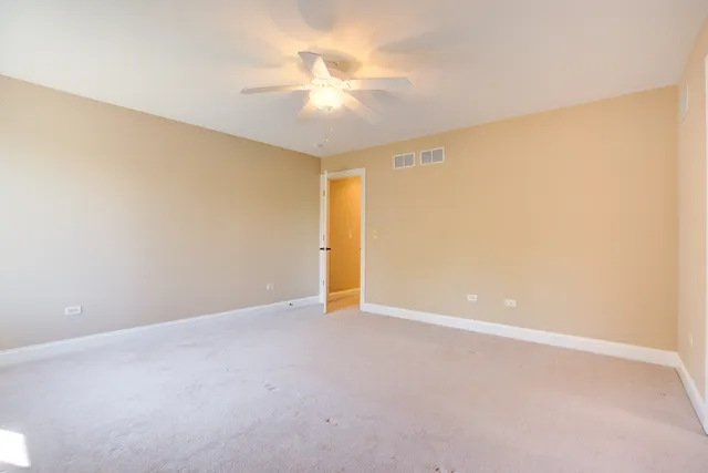 a view of an empty room with a chandelier fan