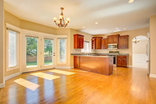 a view of kitchen with granite countertop cabinets and refrigerator