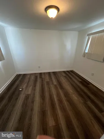 en empty room with wooden floor and windows
