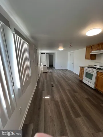 a view of a kitchen with wooden floor and electronic appliances
