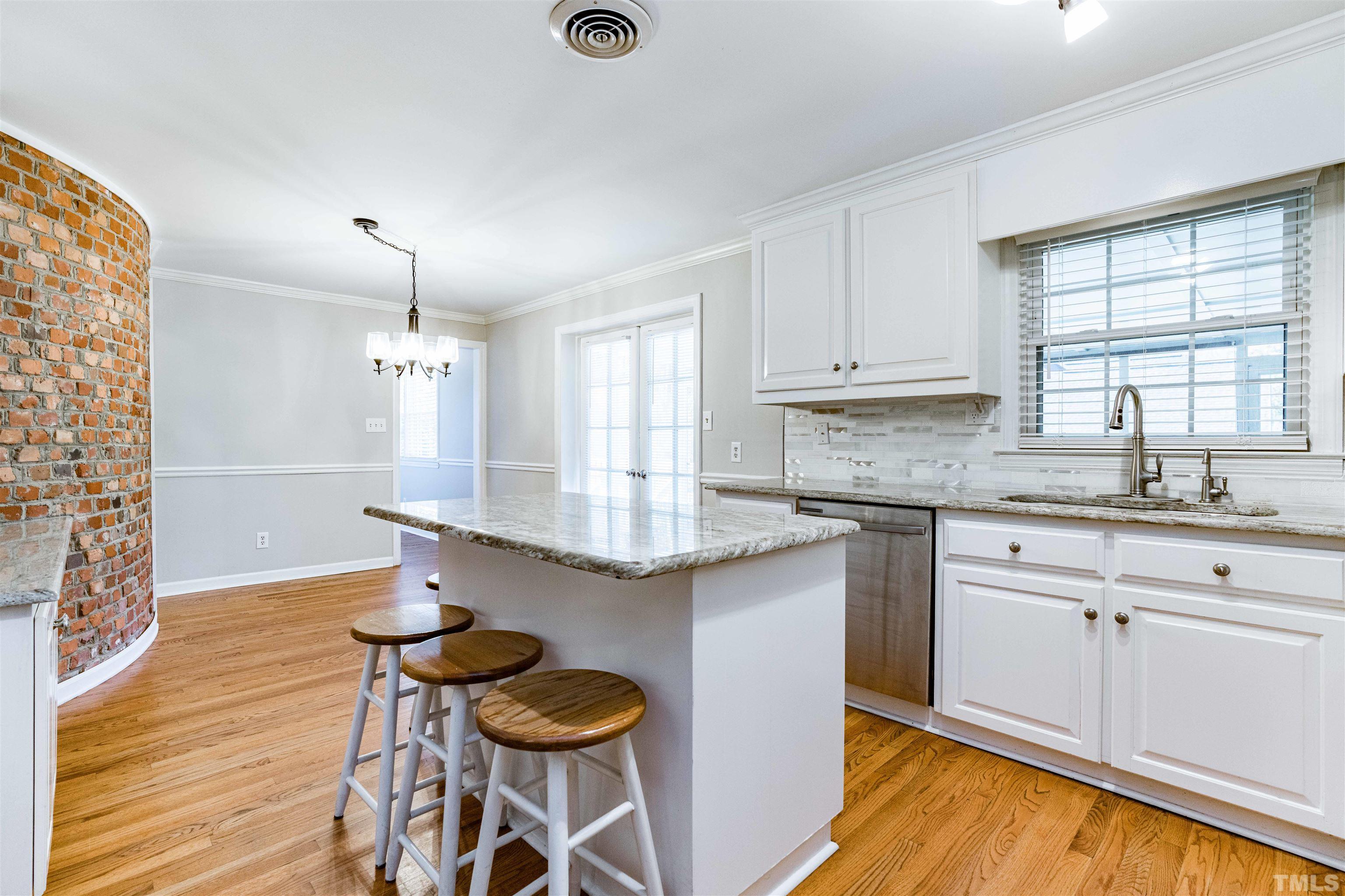 103 Marilyn Circle Cary, NC 27513 - Photo 12 of 64 a kitchen with granite countertop white cabinets and wooden floor