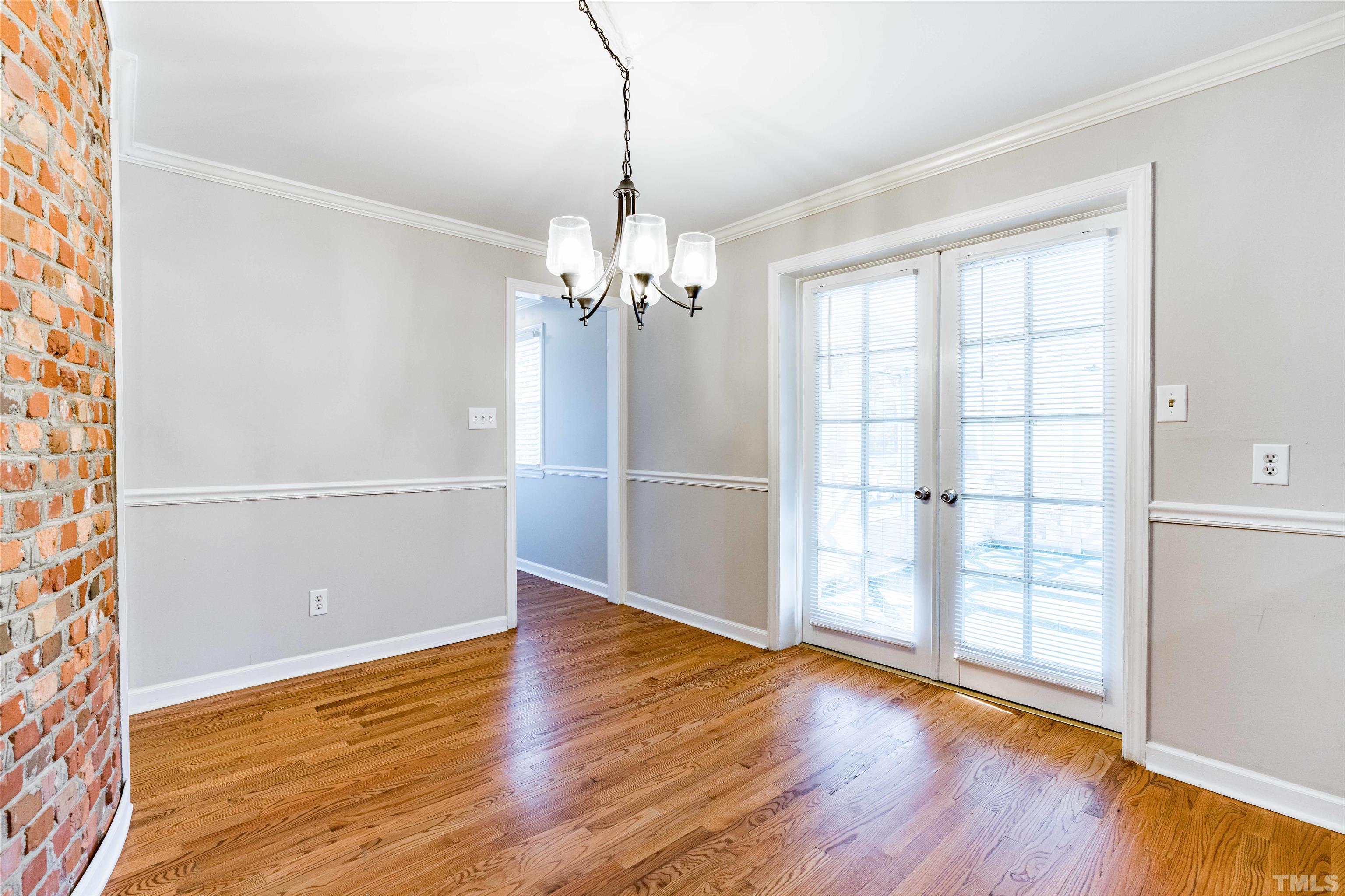 103 Marilyn Circle Cary, NC 27513 - Photo 14 of 64 an empty room with wooden floor cabinet and windows