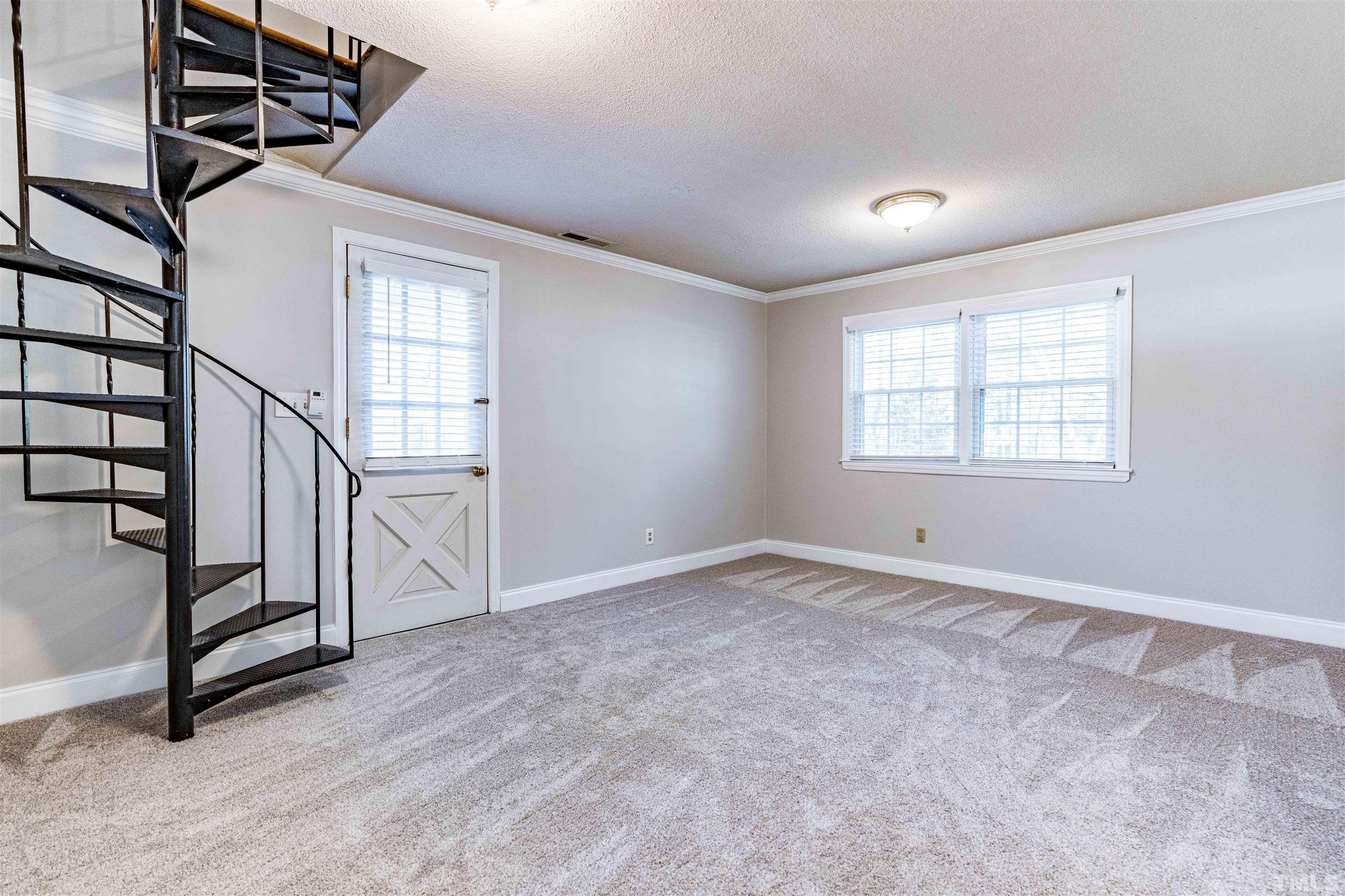103 Marilyn Circle Cary, NC 27513 - Photo 22 of 64 a view of an empty room with stairs and a window