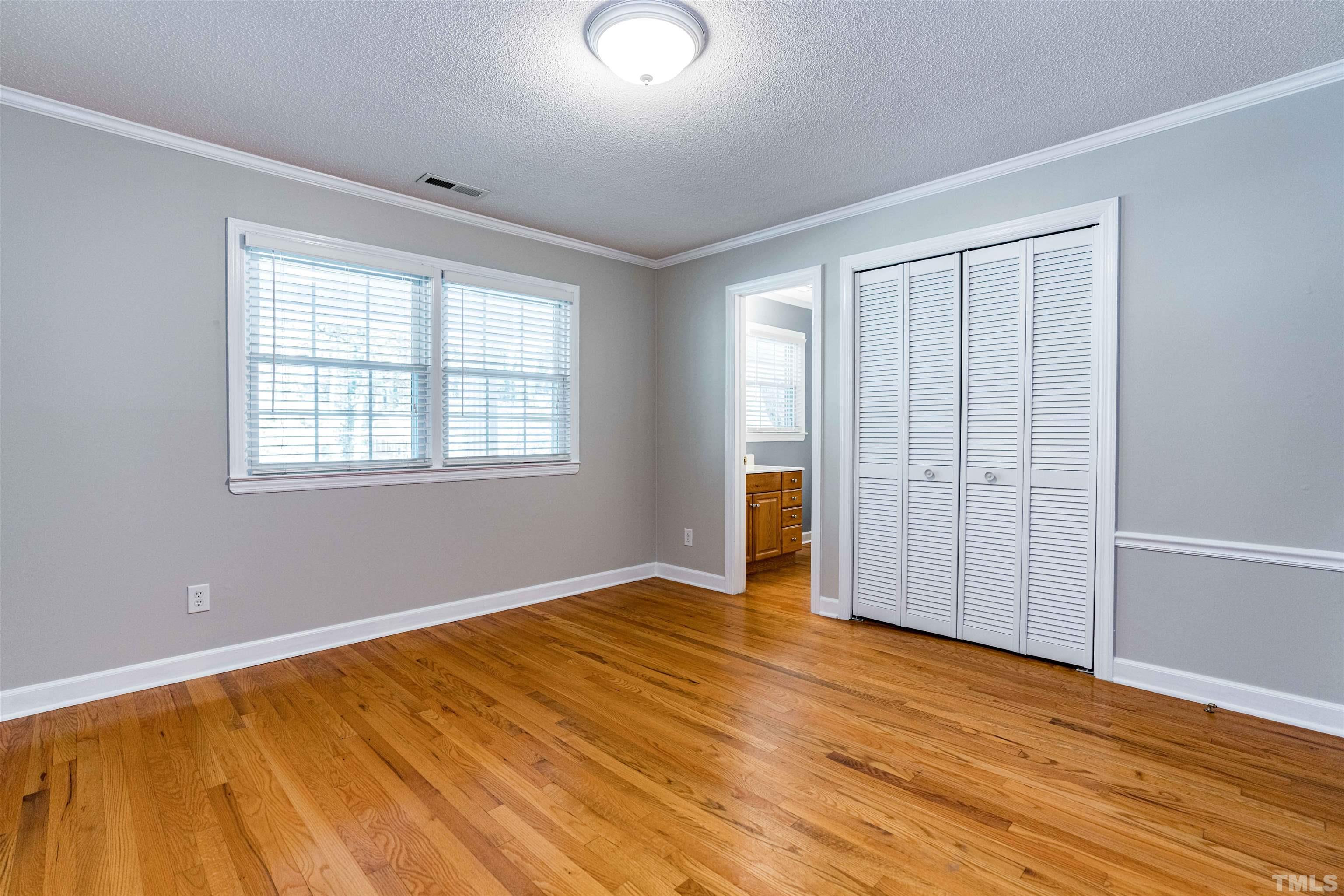 103 Marilyn Circle Cary, NC 27513 - Photo 26 of 64 an empty room with wooden floor and windows
