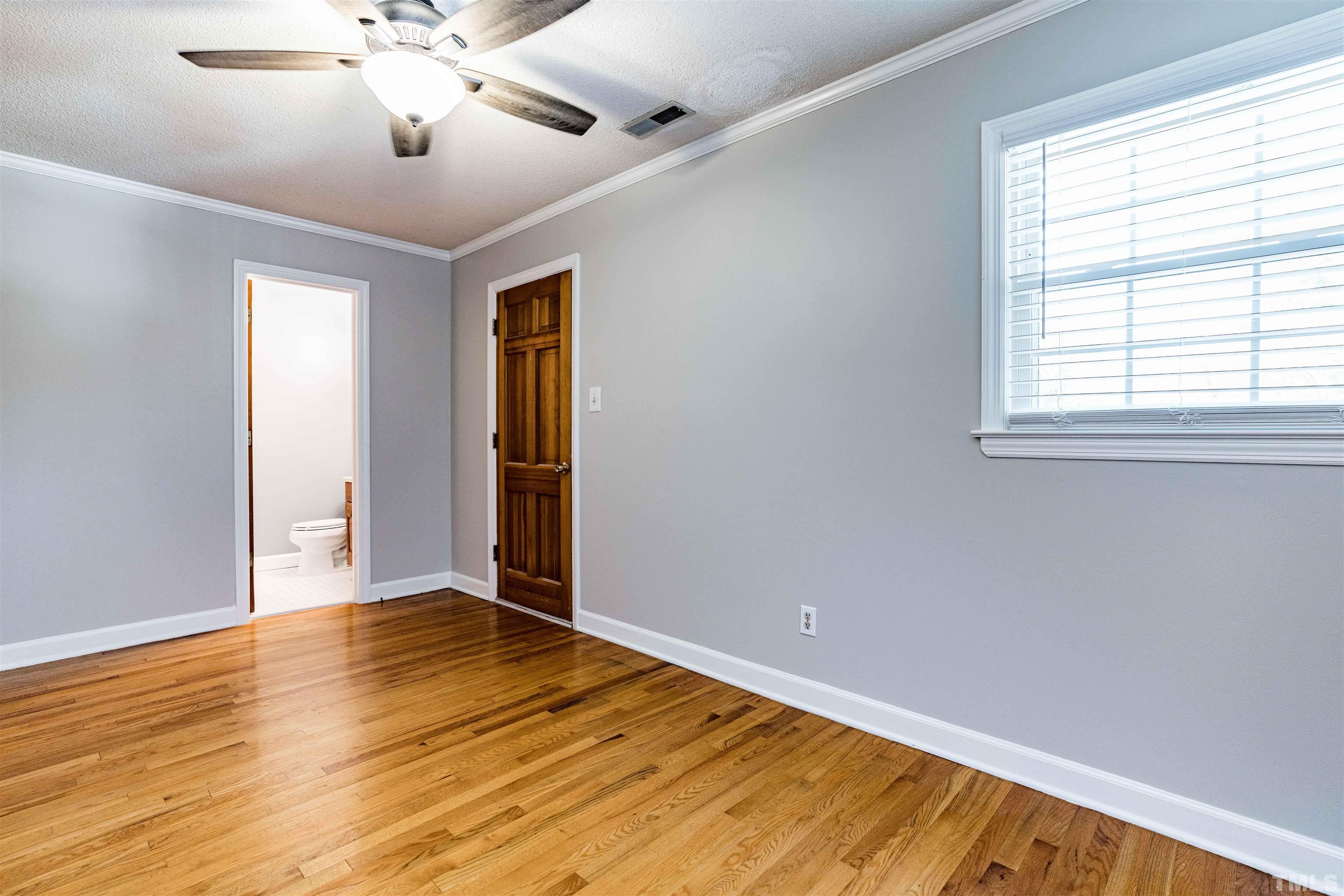 103 Marilyn Circle Cary, NC 27513 - Photo 28 of 64 a view of an empty room with wooden floor and a window