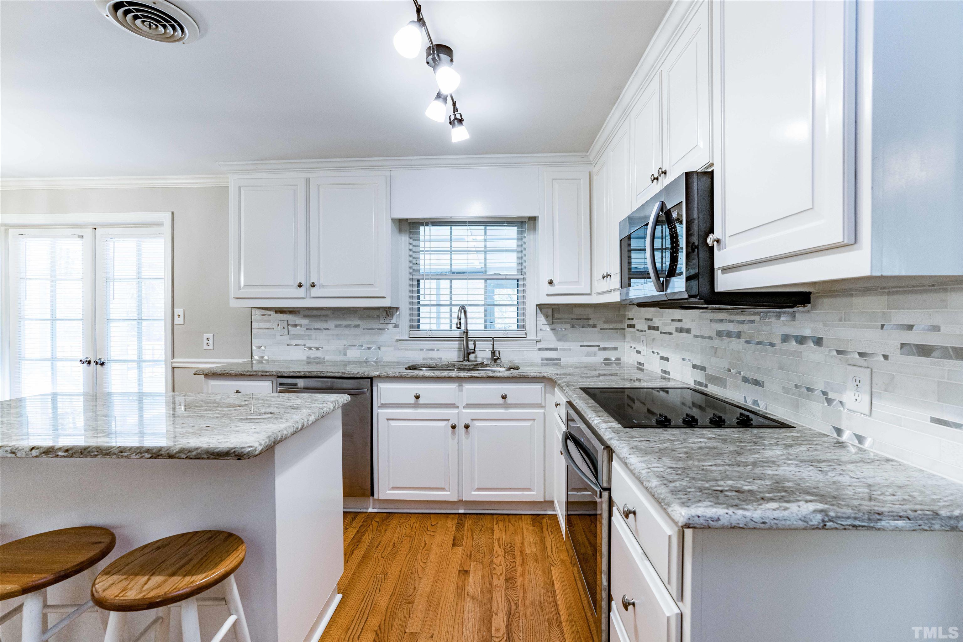 103 Marilyn Circle Cary, NC 27513 - Photo 7 of 64 a kitchen with granite countertop a sink stove and cabinets