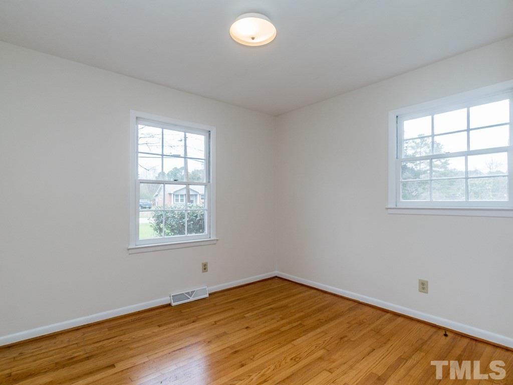 1524 Clermont Road Durham, NC 27713 - Photo 20 of 24 an empty room with wooden floor and windows