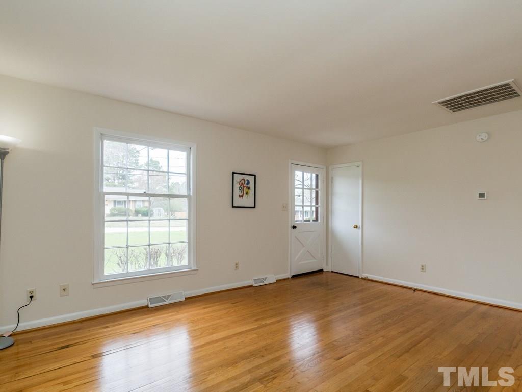 1524 Clermont Road Durham, NC 27713 - Photo 3 of 24 an empty room with wooden floor and windows