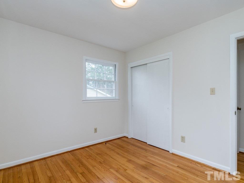1524 Clermont Road Durham, NC 27713 - Photo 21 of 24 a view of an empty room with wooden floor and a window