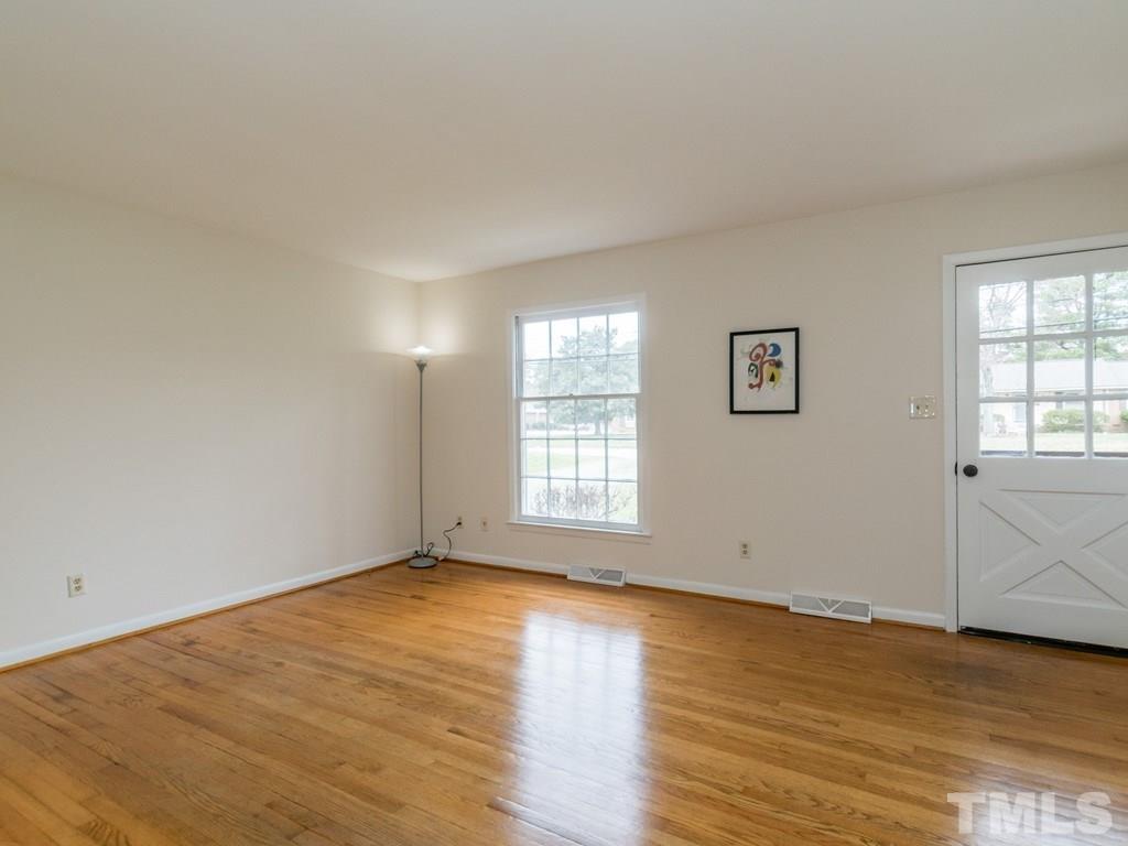 1524 Clermont Road Durham, NC 27713 - Photo 6 of 24 a view of an empty room with wooden floor and a window