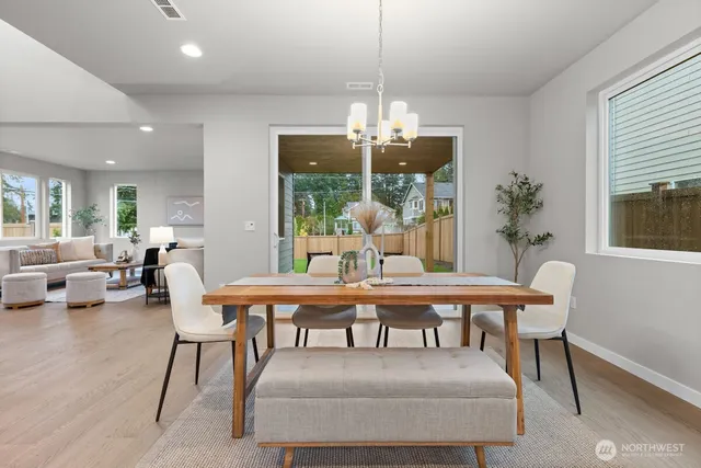 a dining room with furniture a chandelier and wooden floor