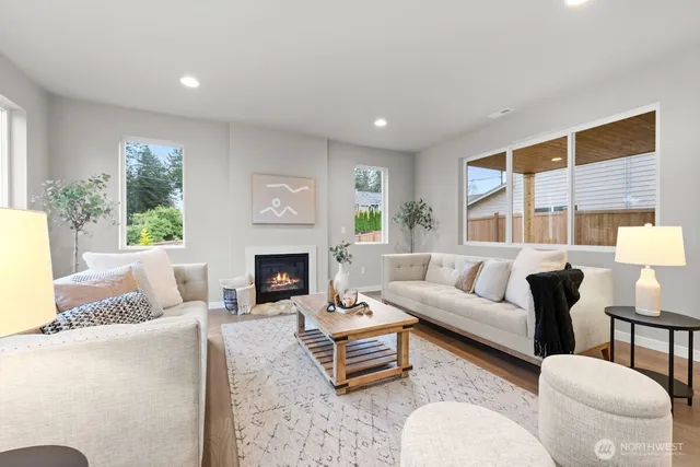 a living room with furniture fireplace and a large window
