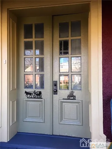 a view of kitchen with white cabinets and window