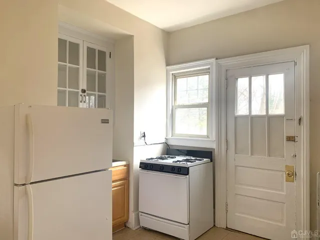 a white refrigerator freezer and a stove sitting inside of a kitchen