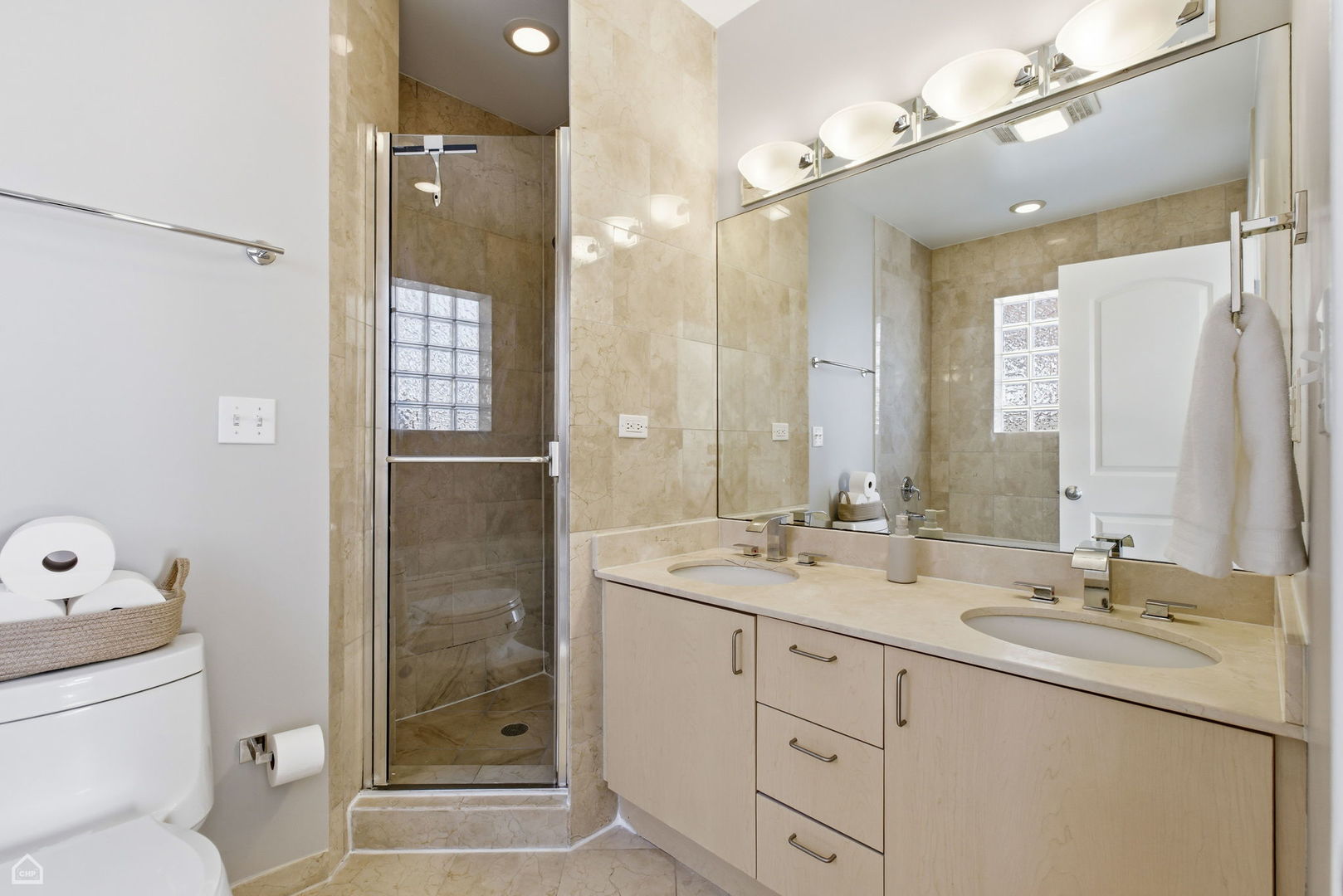 2249 West Foster Avenue, Unit 3 Chicago, IL 60625 - Photo 11 of 19 a bathroom with a double vanity sink mirror and shower