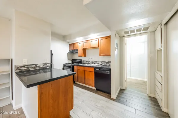 a kitchen with stainless steel appliances granite countertop a stove a sink and a refrigerator