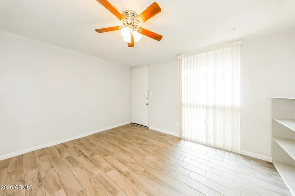 an empty room with wooden floor and windows