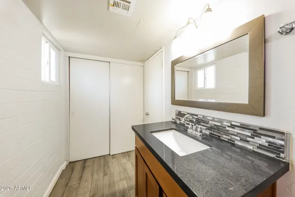 a bathroom with a granite countertop sink and a mirror