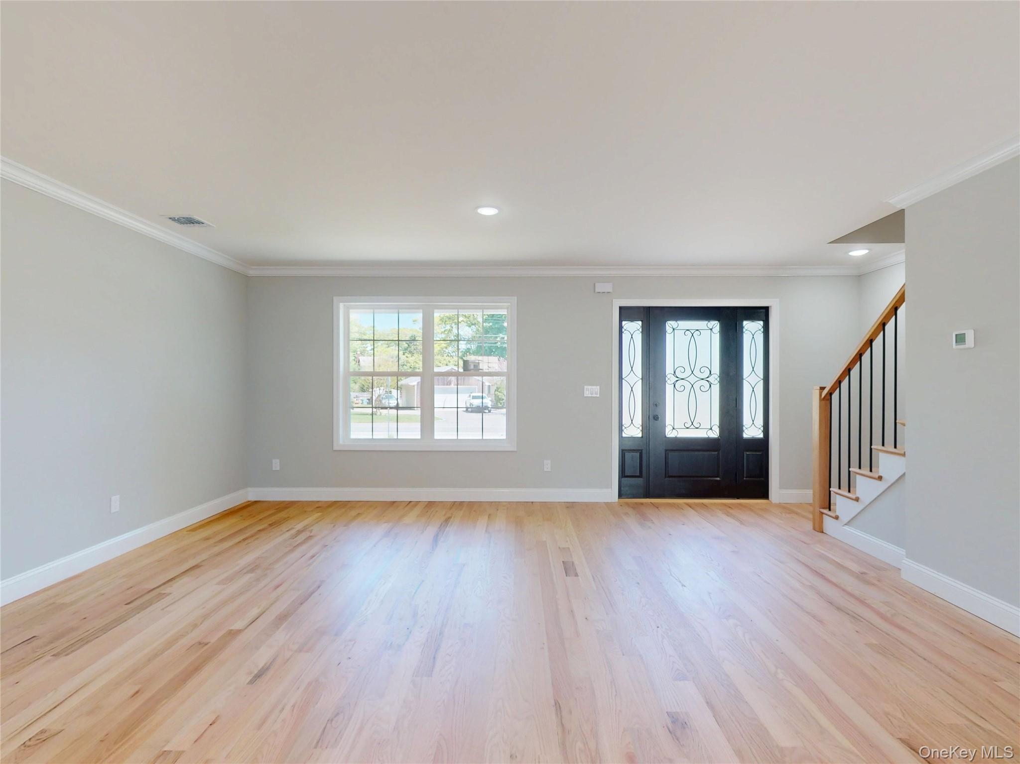 492 Blue Point Road Farmingville, NY 11738 - Photo 2 of 21 a view of an empty room with wooden floor and a window