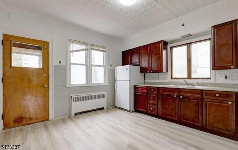 58 Westervelt Avenue Hawthorne, NJ 07506 - Photo 2 of 14 a kitchen with granite countertop wooden cabinets a sink a window and stainless steel appliances