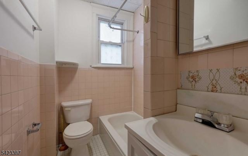 58 Westervelt Avenue Hawthorne, NJ 07506 - Photo 8 of 14 a white toilet sitting next to a bathroom sink