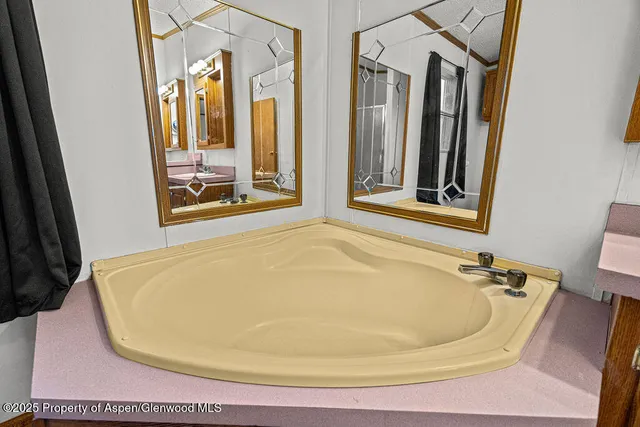 a spacious bathroom with a tub sink and mirror