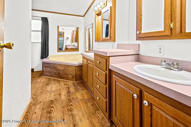 a bed sitting in a spacious bedroom next to a window