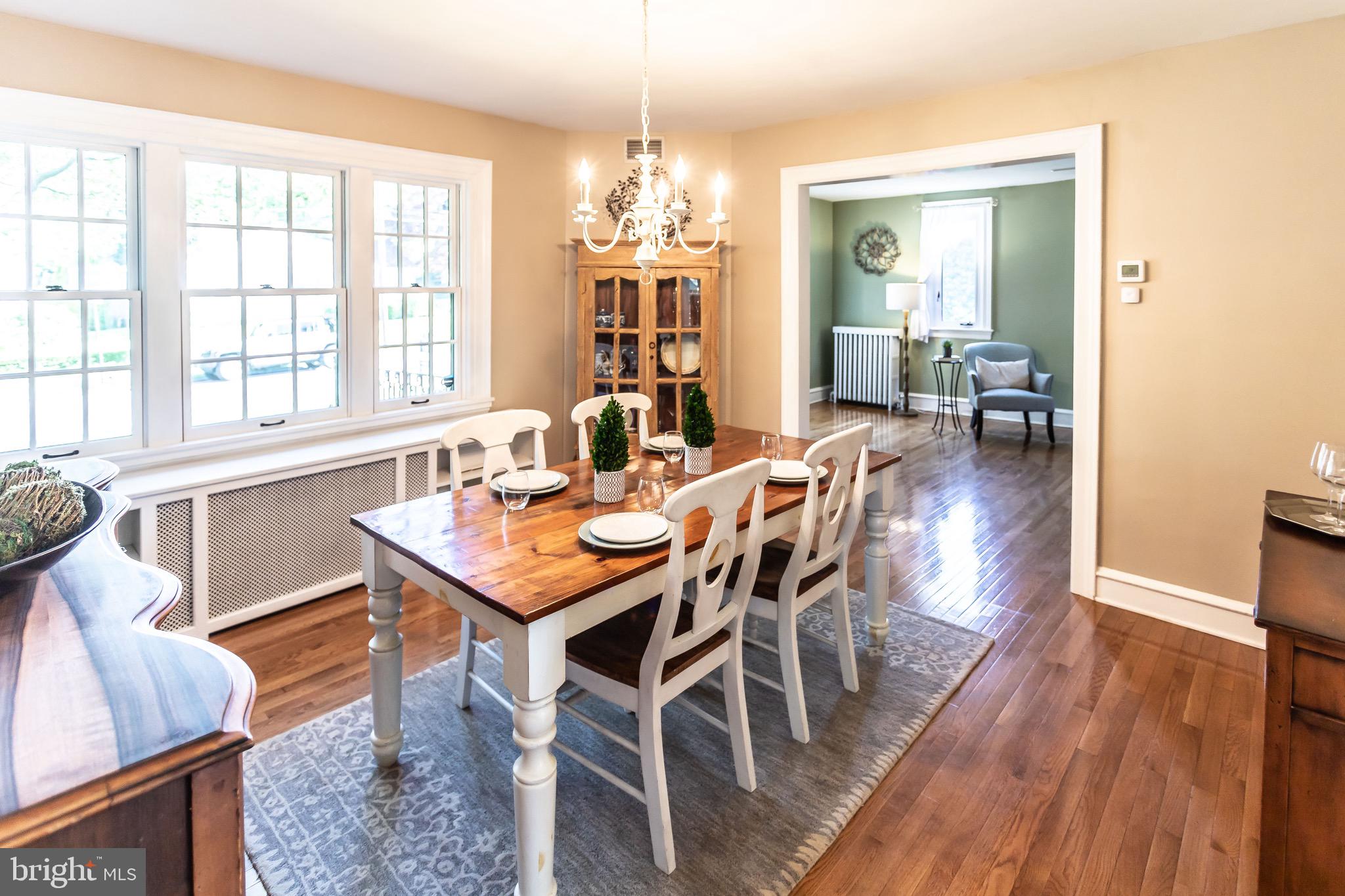105 West Clearfield Road Havertown, PA 19083 - Photo 14 of 56 a dining room with wooden floor a chandelier a wooden table and chairs