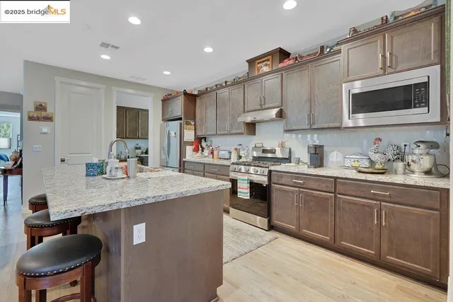 a kitchen with granite countertop a sink stove and refrigerator